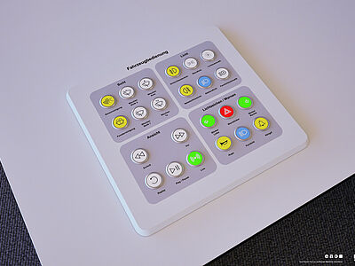 eine weiße Konsole mit bunten Knöpfen liegt auf einem Tisch