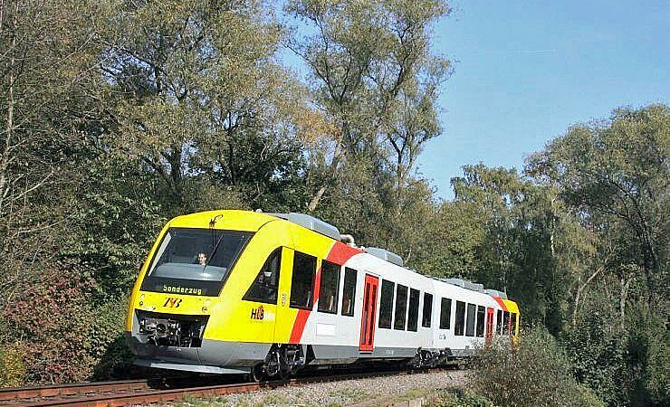 Die Taunusbahn fährt auf einer Strecke durch Wald.
