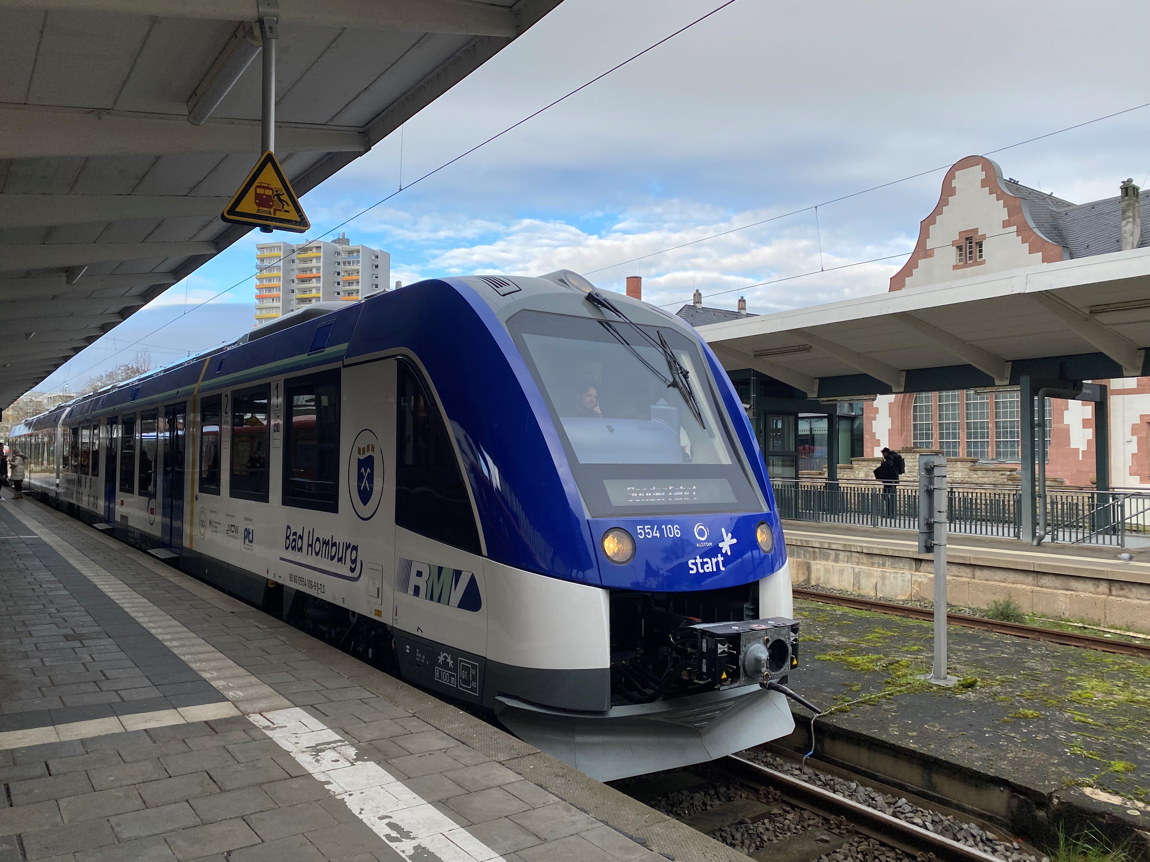 Blauweißer Zug steht auf einem Gleis im Bahnhof